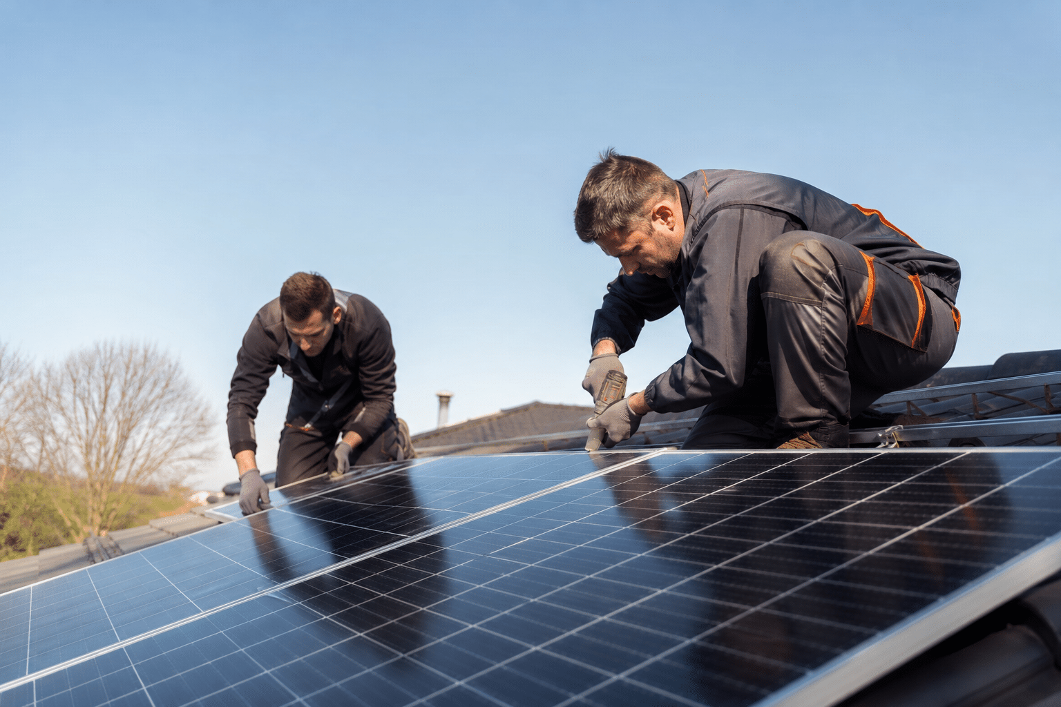 Deux techniciens installant panneaux solaires sur toit