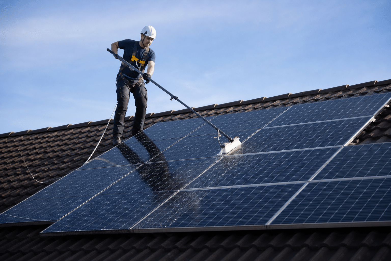 Technicien nettoyant panneaux solaires sur toiture