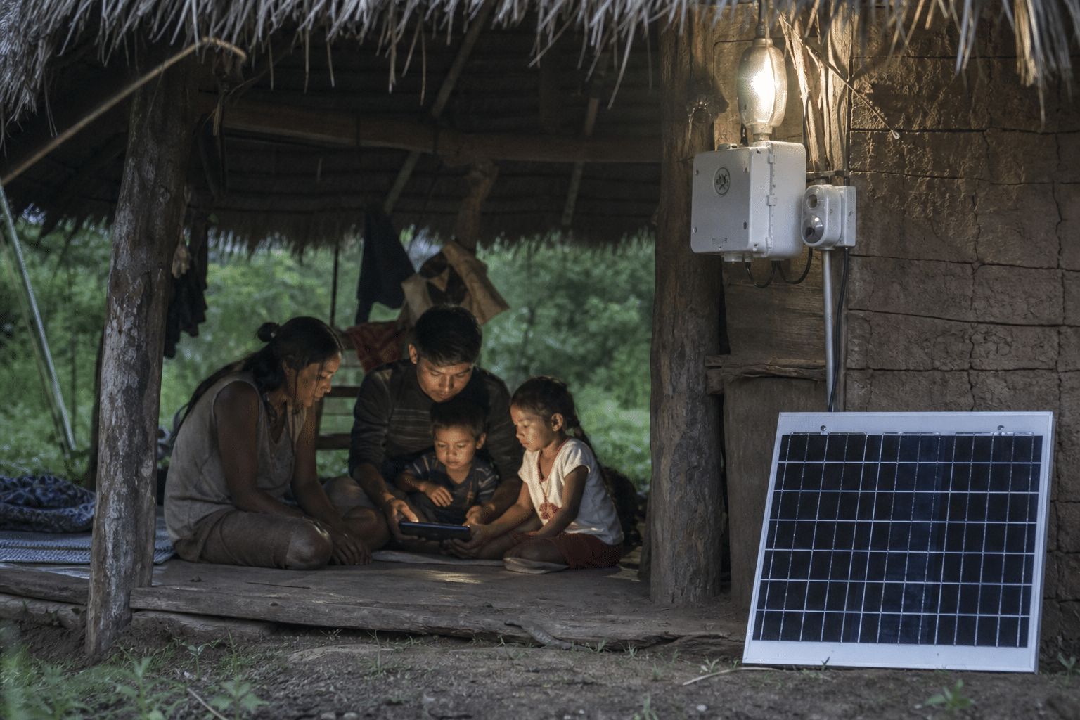 Famille réunie autour d'une lampe alimentée par panneau solaire