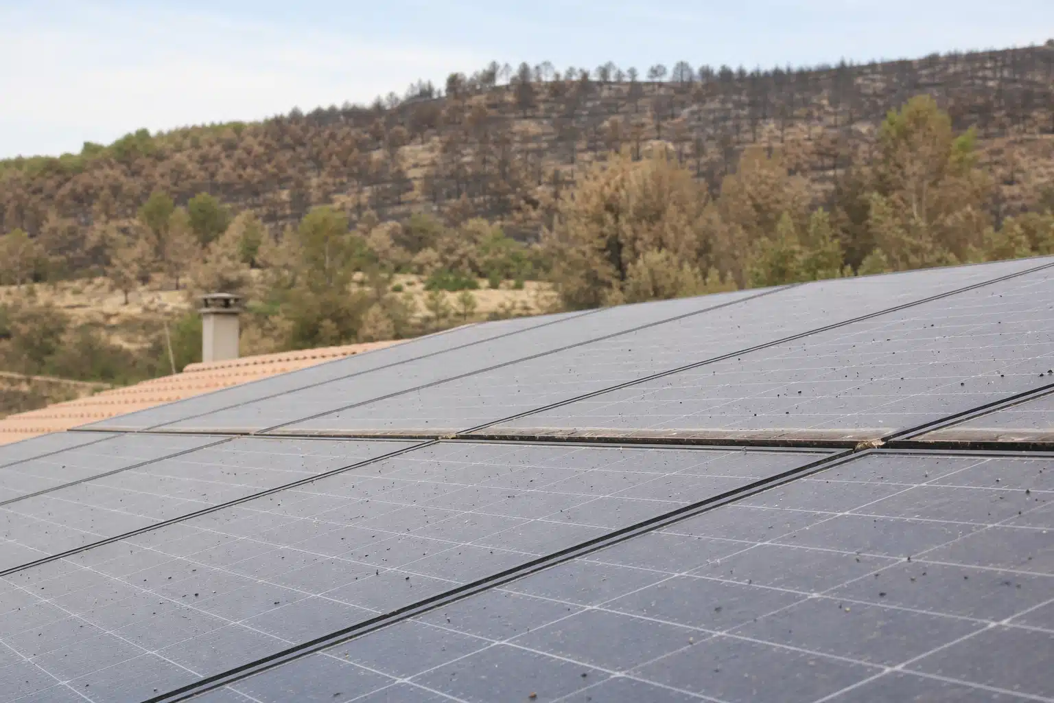 Panneaux solaires sur toit avec collines en arrière-plan